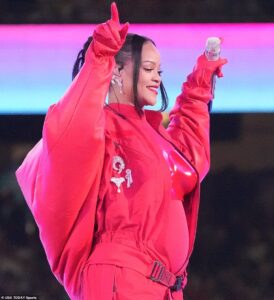 Pregnant Rihanna gives a nod to the late André Leon Talley as she dons a red coat reminiscent of the fashion icon’s blanket jacket for her Super Bowl halftime show performance
